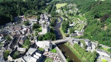 Belçika 'nın Durbuy kentindeki eski kasaba ve kalenin havadan görünüşü, yaz mevsiminde nehirdeki dağlar, nehirler ve kayakçılarla çevrili. Şehrin Panoraması