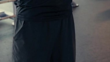 Formda ve genç bir kadın spor salonunda ya da spor salonunda dambıllarla çalışıyor.