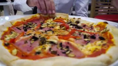 Beyaz bir masada, pizzacıda oturan arkadaşlar İtalyan usulü lezzetli pizzalar yiyorlar. Yemek paylaşımı, arkadaşlarla vakit geçirmek, İtalyan yemeği, taze pişmiş pizza.. 