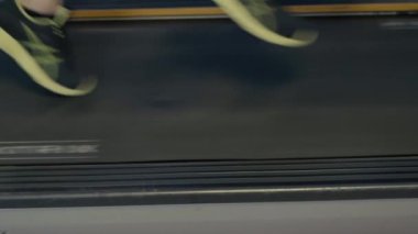 Formda bir adam spor salonunda ya da spor salonunda mekanik koşu bandında hızlı koşar..