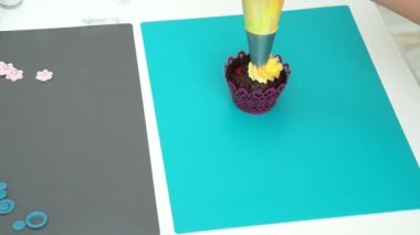 Kremalı kek süslemek. Lezzetli kekin üzerine tereyağlı krema sürerken çekilmiş bir fotoğraf. Konsept: Çalışan kadınlar, serbest meslek, Uluslararası Kadınlar Günü, Kekler ve kekler, ev pastası