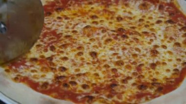 Pişirilmiş pizza, yuvarlak pizza bıçağıyla kesilir. İtalyan pizzacılarının içinde, mükemmel pizza hazırlama süreci