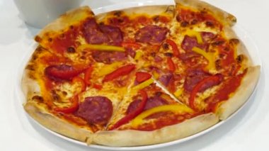 Four friends sitting in a pizzeria at a white table, eating real Italian tasty looking pizza. Concept: Food sharing, spending time with friends, Italian food, fresh baked pizza