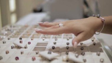 A sales women in a jewelry store is showing beautiful bracelet and ring to a client. Client is delighted. Concept: Luxury jewelry, diamonds, gift, Women's day, Valentines day, luxury, jewelry shop