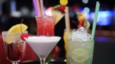 Gece kulübü, bar, disko, bar, margarita, pina colada, sazerac, barmen tarafından hazırlanan Manhattan 'da çeşitli bardaklardaki renkli alkol ve kokteylleri kapatın.
