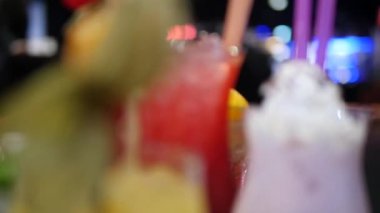 Gece kulübü, bar, disko, bar, margarita, pina colada, sazerac, barmen tarafından hazırlanan Manhattan 'da çeşitli bardaklardaki renkli alkol ve kokteylleri kapatın.