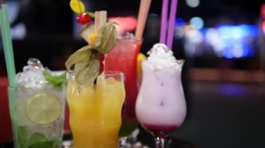 Gece kulübü, bar, disko, bar, margarita, pina colada, sazerac, barmen tarafından hazırlanan Manhattan 'da çeşitli bardaklardaki renkli alkol ve kokteylleri kapatın.
