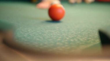 Bilardo kulübünde ya da gece kulübünde bir kadın ya da erkek bilardo oynuyor. Odak noktası turuncu top. Kavram: bilardo, bilardo, bilardo, bilardo, kulüp, bar, eğlence, bar havuzu