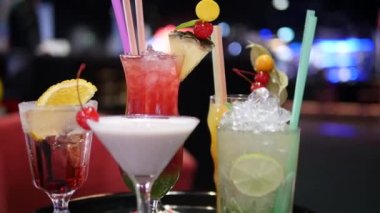 Gece kulübü, bar, disko, bar, margarita, pina colada, sazerac, barmen tarafından hazırlanan Manhattan 'da çeşitli bardaklardaki renkli alkol ve kokteylleri kapatın.