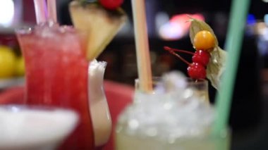 Gece kulübü, bar, disko, bar, margarita, pina colada, sazerac, barmen tarafından hazırlanan Manhattan 'da çeşitli bardaklardaki renkli alkol ve kokteylleri kapatın.