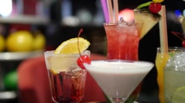 Gece kulübü, bar, disko, bar, margarita, pina colada, sazerac, barmen tarafından hazırlanan Manhattan 'da çeşitli bardaklardaki renkli alkol ve kokteylleri kapatın.