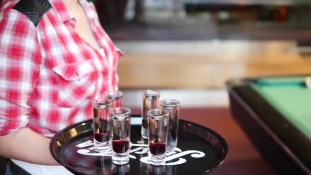 在台球俱乐部或酒吧里 金发女服务员穿着格子衬衫 别针别针 满满一盘的伏特加酒和糖浆 — 图库视频影像