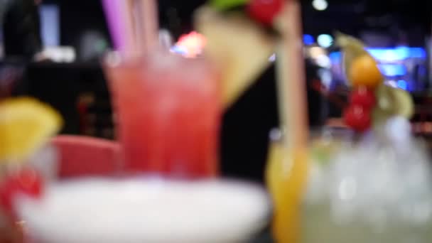 ナイトクラブ ディスコ モヒート マルガリータ ピナコラダ サゼラック バーテンダーが準備したマンハッタンのボケを背景に さまざまなグラスでカラフルなアルコール飲料やカクテルを閉じます — ストック動画