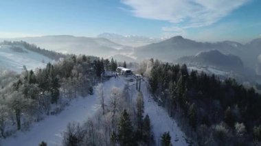 Dağlardaki güzel kayak merkezinin havadan görünüşü. Taze beyaz karla kaplı kış arazisi. Kayak ve snowboard yapmak için mükemmel bir yer. Asansör koltuğu tepeye doğru gidiyor.. 