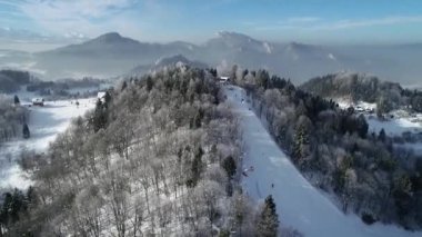 Dağdaki güzel kar beyazı manzaranın havadan görünüşü. Karla kaplı ağaçlar, arka planda yüksek dağlar. Tatra dağlarında kış mevsiminde kayak merkezi.
