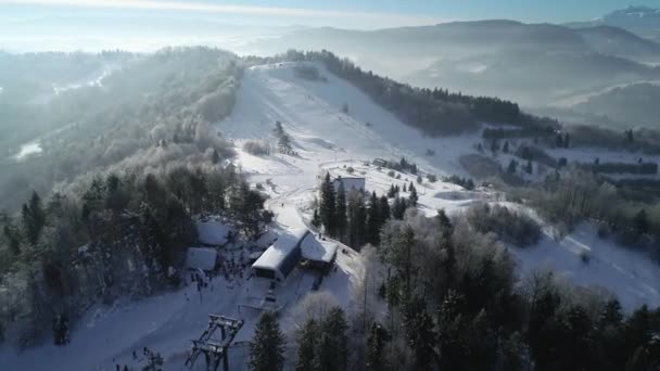 从空中俯瞰高山上美丽的滑雪胜地 冬季的土地上覆盖着新鲜的白雪 滑雪和滑雪板的理想场所 坐电梯的椅子上了山 — 图库视频影像