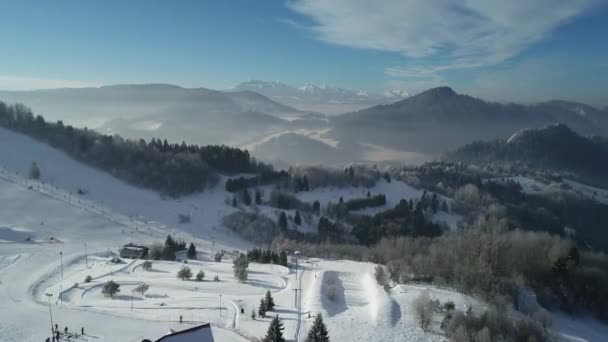 滑雪者和滑雪者在斜坡上滑行的空中景观 波兰塔特拉山的滑雪胜地 阳光灿烂的欧洲 美丽的冬白风景 一切都被雪覆盖 — 图库视频影像