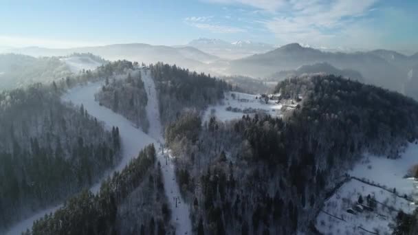 从空中俯瞰高山 滑雪场和滑雪者滑向斜坡 美丽的滑雪胜地 配有滑雪电梯 冬季风景 雪白如雪 寒假期间阳光明媚 完美的滑雪条件 — 图库视频影像