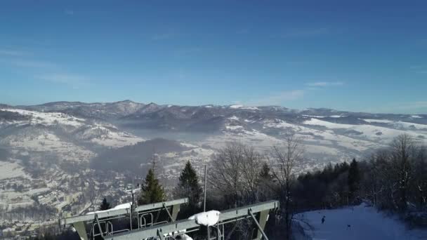 冬季滑雪场的滑雪者坐在轮椅或滑雪车上 在阳光灿烂的日子里 滑雪者们坐在轮椅上观看空中风景 一切都被白雪覆盖了 在波兰滑雪 滑雪胜地 — 图库视频影像