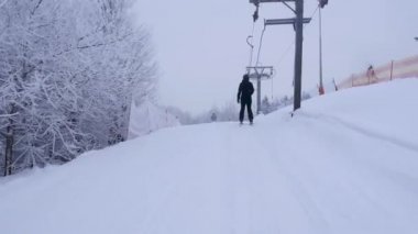 Beyaz kış mevsiminde kayak merkezi. Kayakçının kayak kaldıracı tipinde bir T-bar sürüşünün görüntüsü. Karla kaplı güzel bir manzara.