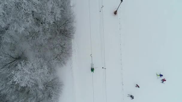 从空中俯瞰滑雪者骑上T形杠的景象 有许多游客的冬季滑雪胜地 一切都被白雪覆盖了 — 图库视频影像