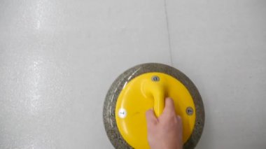 Pov, bigudi tutmanın ve buz tabakasında kayan kaygan taşın bakış açısı. Kış olimpiyat oyunu. 