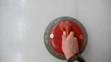 Pov, bigudi tutmanın ve buz tabakasında kayan kaygan taşın bakış açısı. Kış olimpiyat oyunu. 