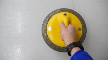 Pov, bigudi tutmanın ve buz tabakasında kayan kaygan taşın bakış açısı. Kış olimpiyat oyunu. 