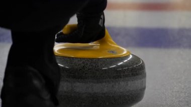 Curling taşı başka bir taşa çarpıyor ve buz tabakasında kayıyor. Konsept: Kış takım sporu, olimpiyat oyunları, kıvırma, kıvırma oyuncuları.