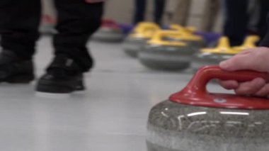 Curling taşı başka bir taşa çarpıyor ve buz tabakasında kayıyor. Konsept: Kış takım sporu, olimpiyat oyunları, kıvırma, kıvırma oyuncuları.