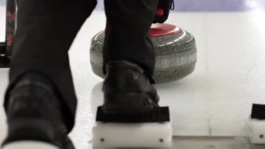 Körling maçı. Bigudiler buz pateni sahasında körling oynuyorlar. Granit taş buz tabakasında kayıyor. Kış olimpiyatlarında körling bir takım sporudur..