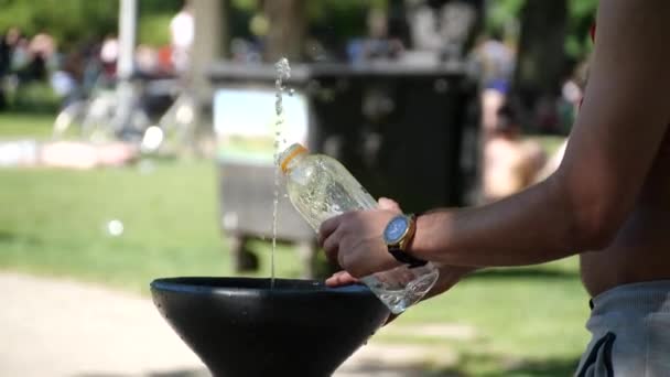 男は公共の緑の公園で噴水を飲むから水でボトルを埋めます 生態学 使用Oプラスチックボトル 生態学的アプローチ 生態学者 — ストック動画