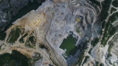 Açılmış maden ocağının havadan görünüşü. Çalışan bir sürü makine, kazıcı ve matkapla birlikte. Yukarıdan 4k görüntü