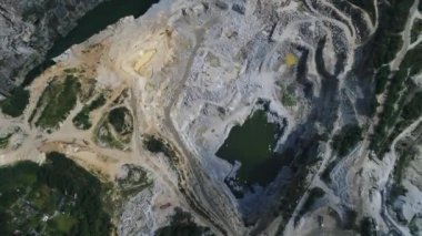 Açılmış maden ocağının havadan görünüşü. Çalışan bir sürü makine, kazıcı ve matkapla birlikte. Yukarıdan 4k görüntü
