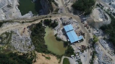 Açılmış maden ocağının havadan görünüşü. Çalışan bir sürü makine, kazıcı ve matkapla birlikte. Yukarıdan 4k görüntü