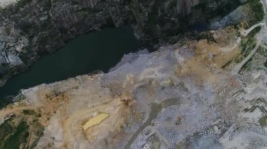 Açılmış maden ocağının havadan görünüşü. Çalışan bir sürü makine, kazıcı ve matkapla birlikte. Yukarıdan 4k görüntü