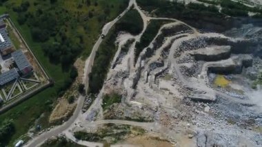 Açılmış maden ocağının havadan görünüşü. Çalışan bir sürü makine, kazıcı ve matkapla birlikte. Yukarıdan 4k görüntü