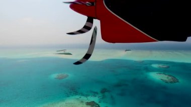 Deniz uçağı ya da deniz uçağı Maldivian ya da Seyşel Adaları 'ndaki bir yere iniyor. Çalışan uçak pervaneleri