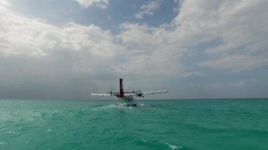 Deniz uçağı ya da deniz uçağı Maldivler ya da Seyşeller Adası 'ndaki bir suya iniyor.. 
