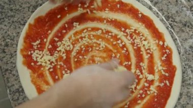 Pizza manzarası yapıyorum. Profesyonel bir mutfakta deneyimli bir şef İtalyan pizzası hazırlar. Şef hamuru domates sosu, mozarella ve malzemelerle dolduruyor.