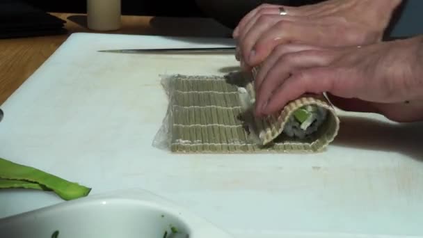 寿司職人は 日本料理店で新鮮でおいしい寿司ロールを準備し プレートに置きます コンセプト 竹の間に巻き寿司ロールを転がす — ストック動画