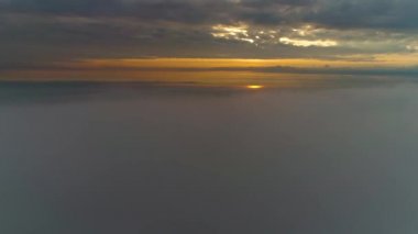 Güneş doğarken bulutların üzerinde uçan hava manzarası. Hareket eden kabarık bulutların manzarası. İHA yüksekten uçuyor. Logo veya metin için mükemmel bir arkaplan. Bulutların ve stratosferin üstündeki düzlem perspektifi