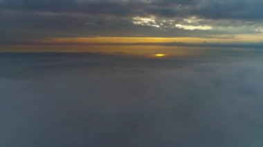 Güneş doğarken bulutların üzerinde uçan hava manzarası. Hareket eden kabarık bulutların manzarası. İHA yüksekten uçuyor. Logo veya metin için mükemmel bir arkaplan. Bulutların ve stratosferin üstündeki düzlem perspektifi