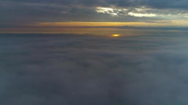 Güneş doğarken bulutların üzerinde uçan hava manzarası. Hareket eden kabarık bulutların manzarası. İHA yüksekten uçuyor. Logo veya metin için mükemmel bir arkaplan. Bulutların ve stratosferin üstündeki düzlem perspektifi