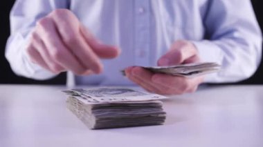 Bir sürü para konsepti. Tişörtlü iş adamı sayıyor ve bir yığın banknot atıyor. Konsept: Bankadan borç para, uzaktan çalışma, evden çalışma, krediler, krediler, para kazanmak, Polonya para birimi
