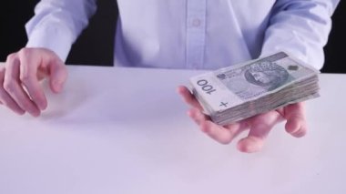 Bir sürü para konsepti. Gömlekli bir iş adamı Polonya parası gösteriyor. Konsept: kredi, uzaktan çalışma, kredi verme, para kazanma, Polonya para birimi, kazanç, Polonya 'da iş