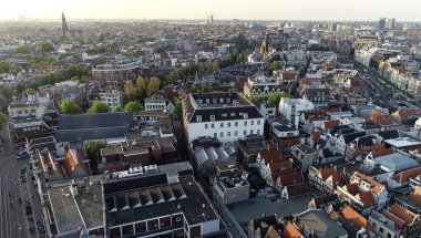 Hollanda, Avrupa 'daki Amsterdam' ın panoramik hava manzarası. Kanal ve eski merkez bölgenin yukarısına bak. Amsterdam 'daki ünlü yerler ve tipik Alman mimarisi güzel ve sıcak renklerde.