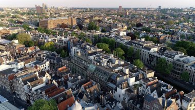 Hollanda, Avrupa 'daki Amsterdam' ın panoramik hava manzarası. Kanal ve eski merkez bölgenin yukarısına bak. Amsterdam 'daki ünlü yerler ve tipik Alman mimarisi güzel ve sıcak renklerde.