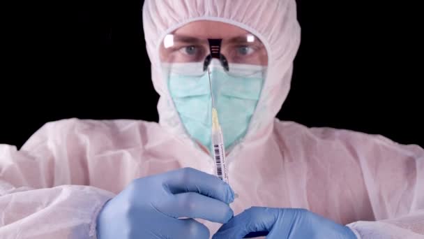 白の安全制服の男 マスクとメガネは コロナウイルスを治すためにワクチンや注射器を示しています Covid 2019のコンセプト 世界的な流行 パンデミックの治療 流行の停止 武漢からのウイルスのワクチン — ストック動画