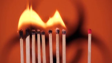 Evde kal, Coronavirüs salgınını önle. Biyolojik tehlike arkaplanındaki eşleşmeler yakılıyor. Kavram: Yayılan salgın, domino etkisi, COVID-19, Wuhan virüsü, izole edilmiş kibritler, Dünya için dua et.